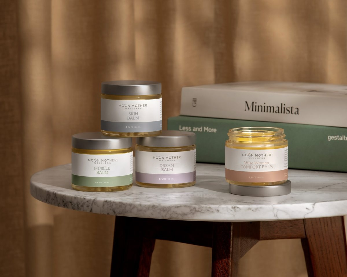 Moon Mother Wellness Skin, Muscle, Dream and Wise Woman Comfort balms on a marble side table